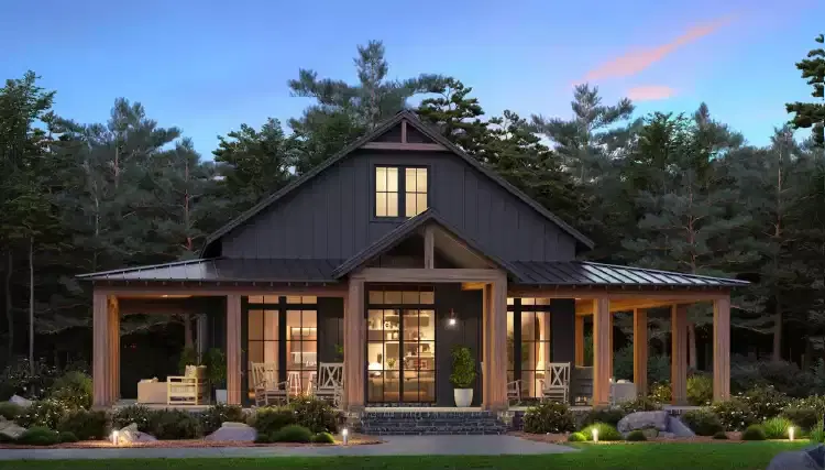 Luxury dark grey post-frame home nestled in a wooded lot, featuring a large symmetrical front porch with heavy timber framing and large windows.